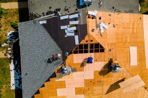 During repair work on apartment buildings roof old shingles were replaced plywood and new shingles were installed.